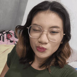 Portrait of VIXIA, a female DKLT Designs team member, wearing glasses and making a playful face.