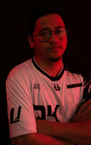 A Portrait of DARKRYM, Founder/CEO and Creative Lead of DKLT Designs. Wearing an E-sports jersey with red lighting.
